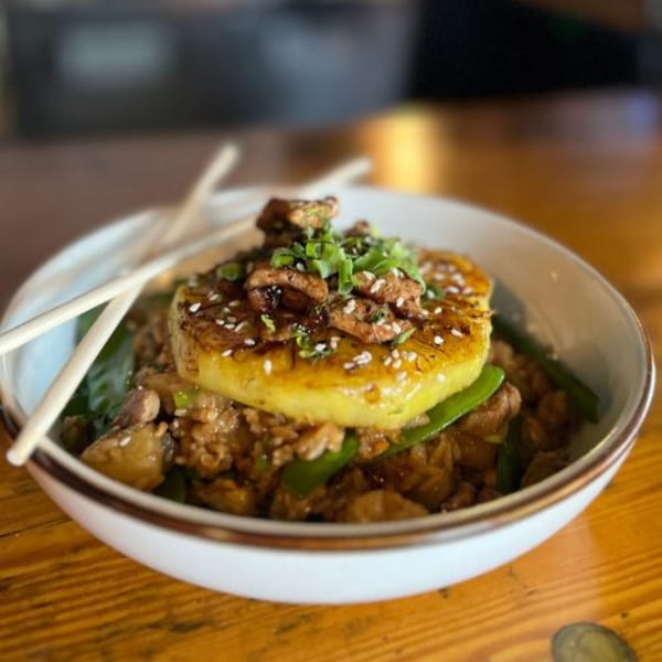 Alyce cafe's pineapple fried rice with grilled pineapple, sesame seeds, and green onions.