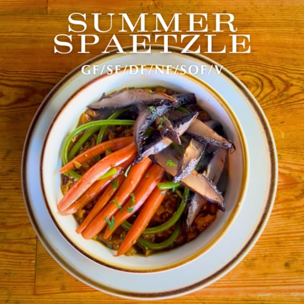 Alyce's Summer Spaetzle with carrots, green beans, and mushrooms in a bowl on a wooden table.