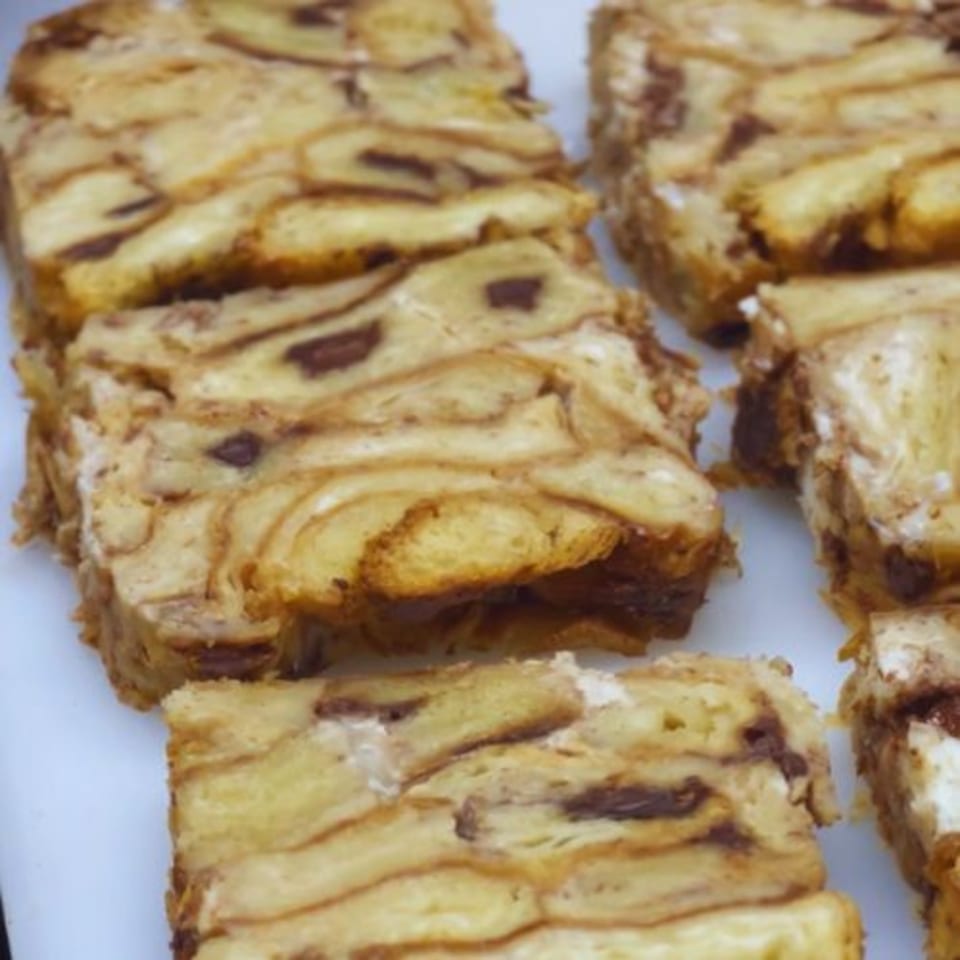 Close-up of Alyce cafe's bread pudding slices with chocolate swirls and creamy filling.