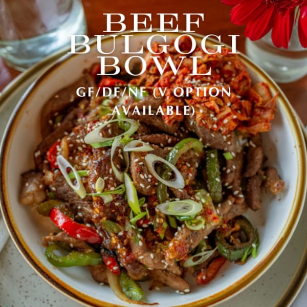 A Beef Bulgogi Bowl from Alyce cafe, topped with kimchi, green onions, and sesame seeds.